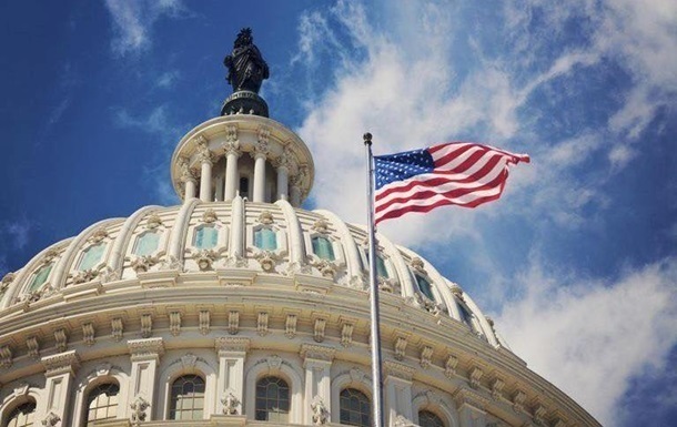 Будівля Капітолію США у Вашингтоні на тлі прапорів
