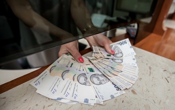 Аналітик переглядає статистичні дані про рівень заробітної плати в Україні на моніторі